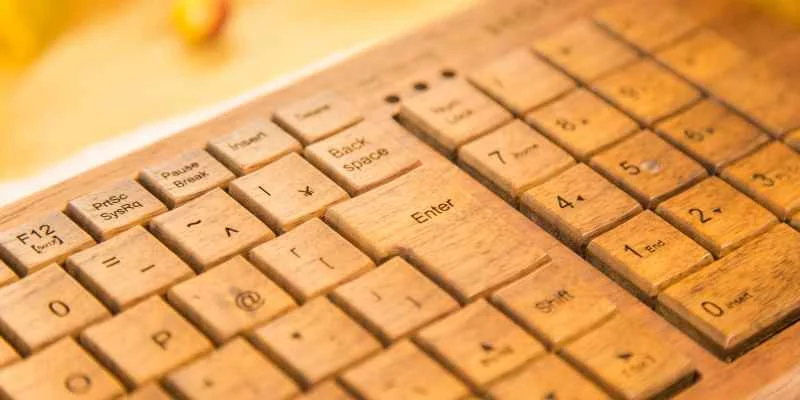 Close-up of a wooden mechanical keyboard with engraved wood keycaps