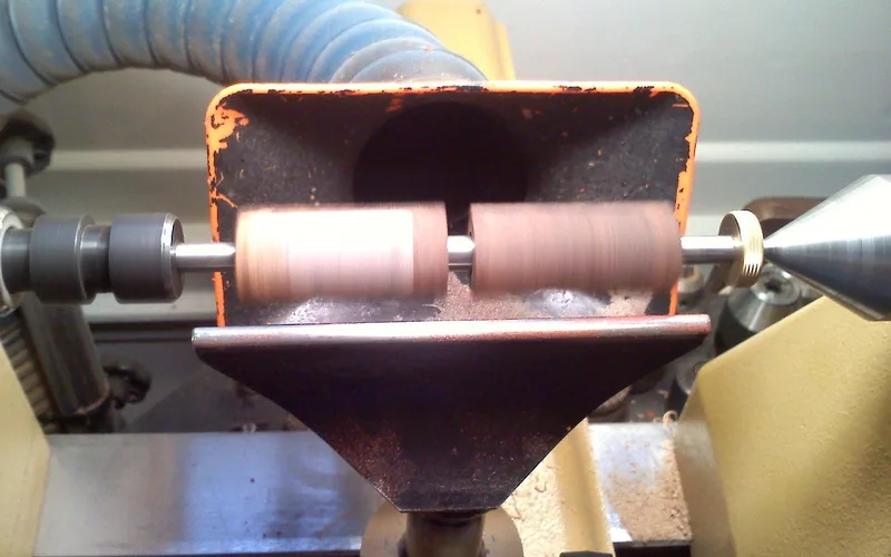 Wood shavings and sawdust accumulating around a lathe in a woodworking workshop