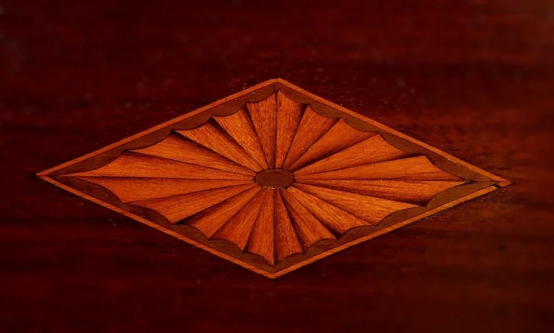 Sunburst wood marquetry inlay, the kind of fine detail cut with jeweler's-style saw blades