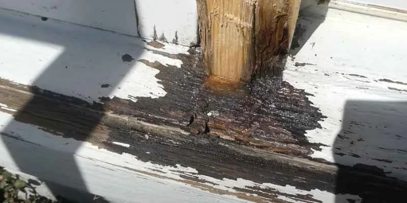 Weathered wood post showing surface rot and old fasteners, the kind of damage wood hardener is designed to treat