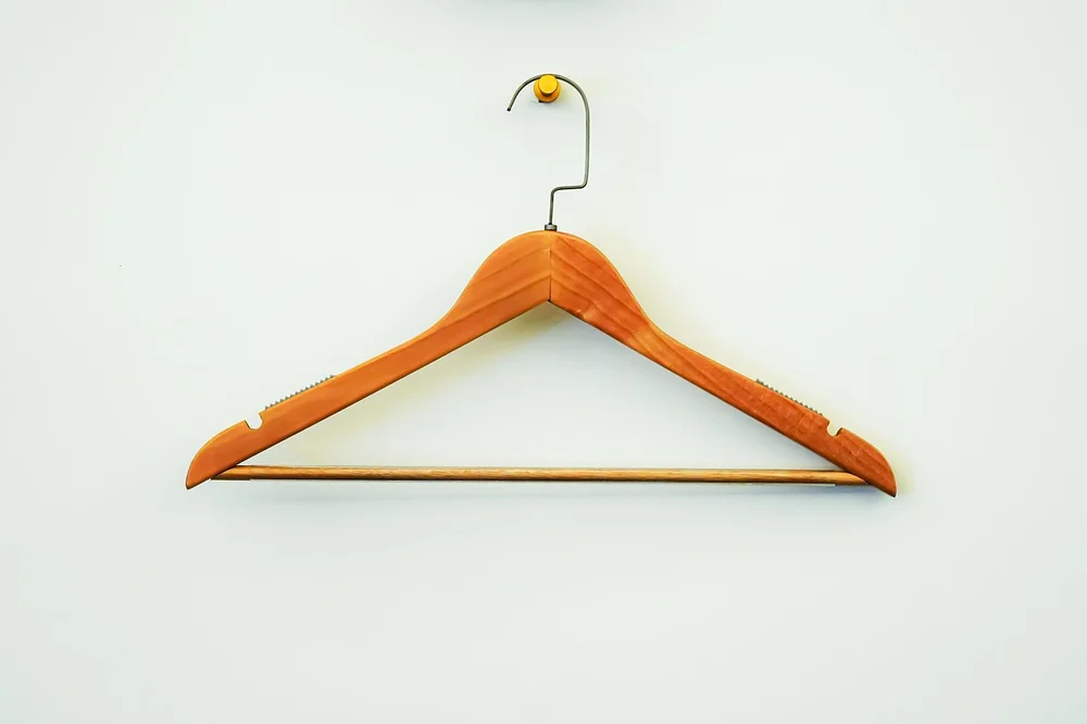 Wooden hanger with cut notches along the shoulder used to hold thin straps in place Wooden hanger with cut notches along the shoulder used to hold thin straps in place