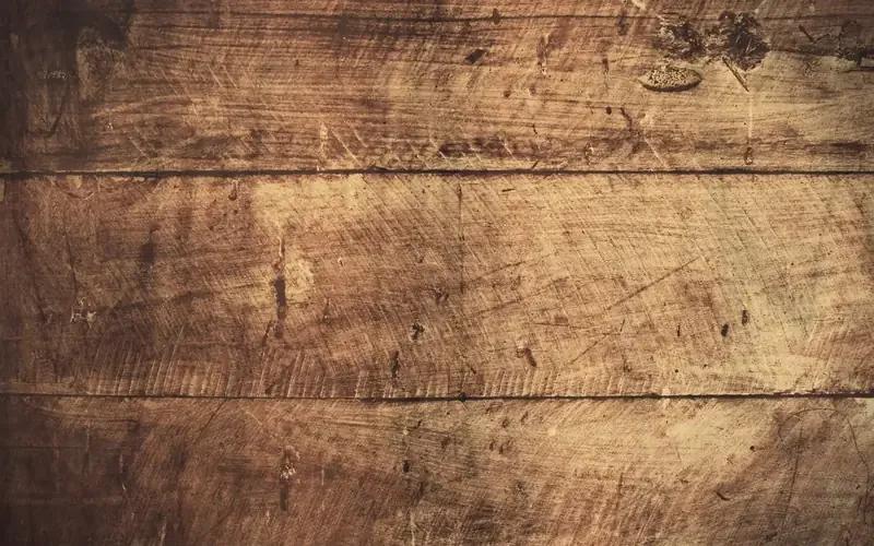 Close-up of worn, scratched hardwood floorboards with a dull finish Close-up of worn, scratched hardwood floorboards with a dull finish