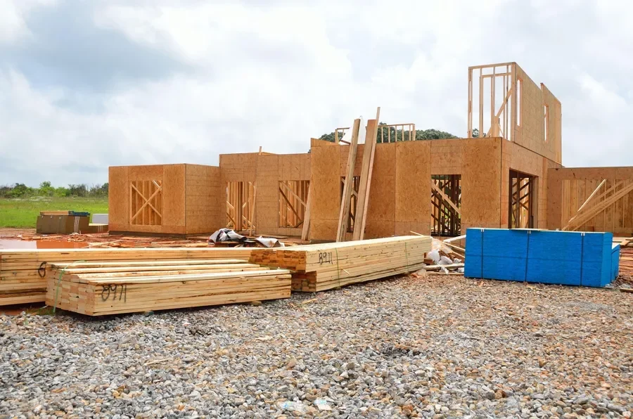 Wall panels and stacked lumber on a framing job site