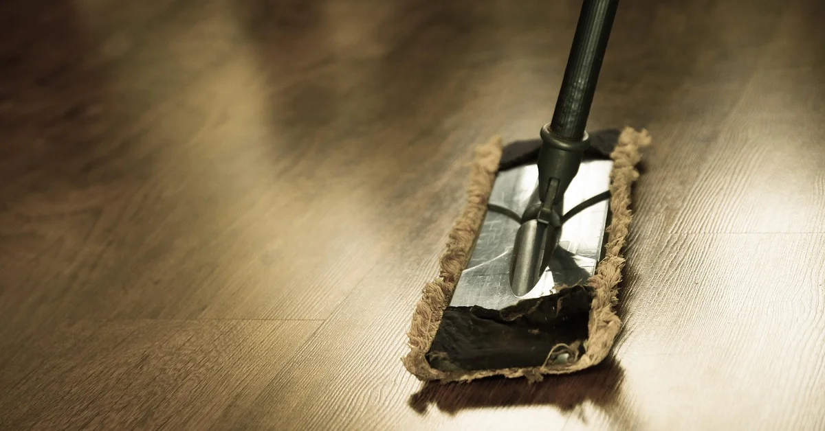 Flat mop cleaning a hardwood floor with a spray-and-wipe cleaner