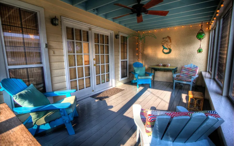 Covered porch with a painted ceiling, ceiling fan and outdoor seating Covered porch with a painted ceiling, ceiling fan and outdoor seating