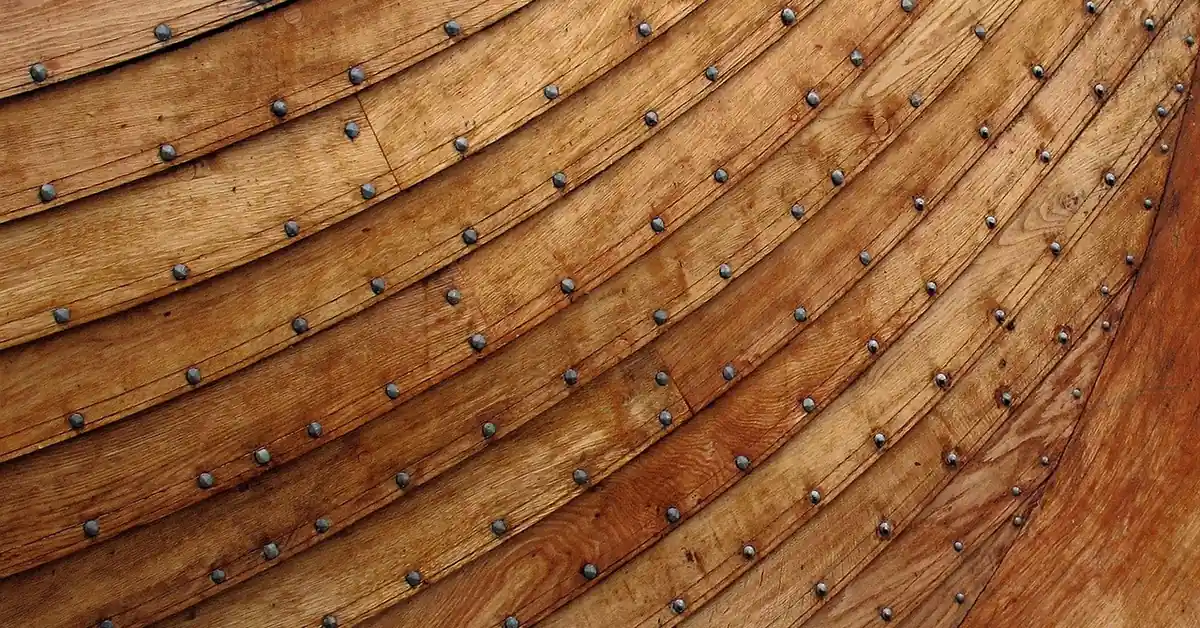 Curved wooden planks riveted along a boat hull