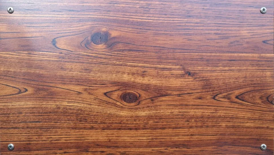 A finished faux wood grain finish on a metal panel
