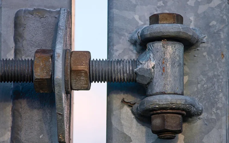 Galvanized steel hinge with bolt and nuts, close up