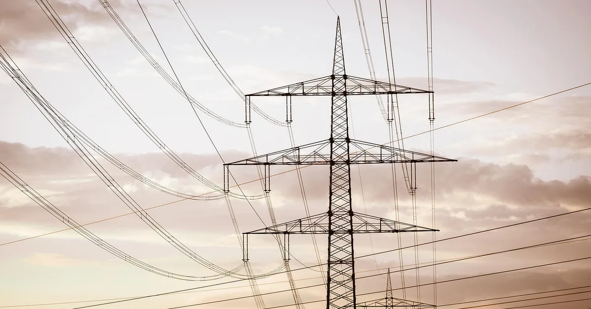 high-voltage electrical transmission lines against the sky, representing the lethal current risk of DIY wood burning