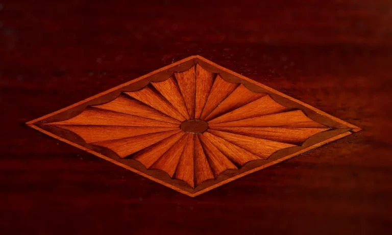 Sunburst marquetry inlay made from wood veneer on a mahogany surface