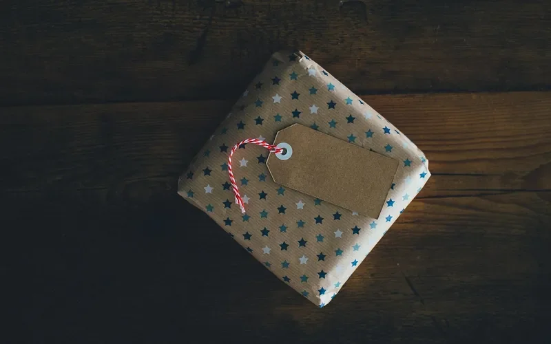 Kraft gift tag tied with red and white twine on a wrapped gift