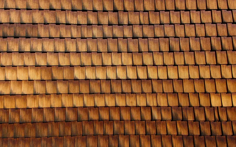 Close-up of weathered wood shingle cladding showing overlapping shake pattern Close-up of weathered wood shingle cladding showing overlapping shake pattern