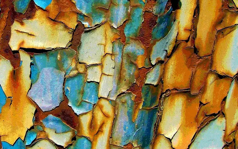 Layers of peeling paint over rusted steel