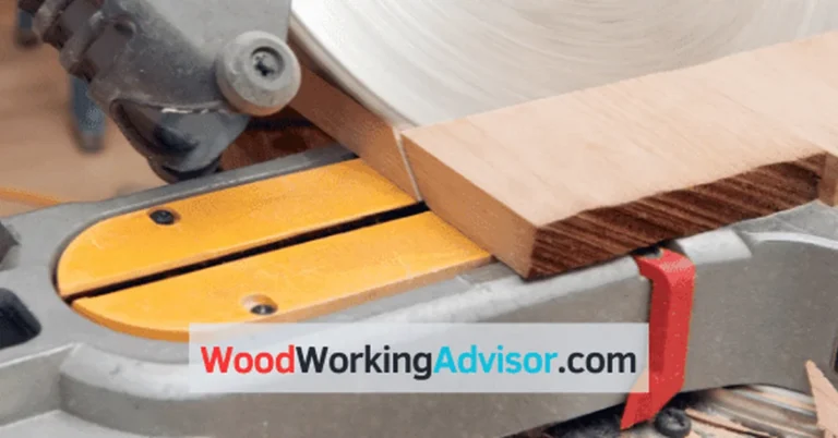 Miter saw blade cutting through a wood board on the fence