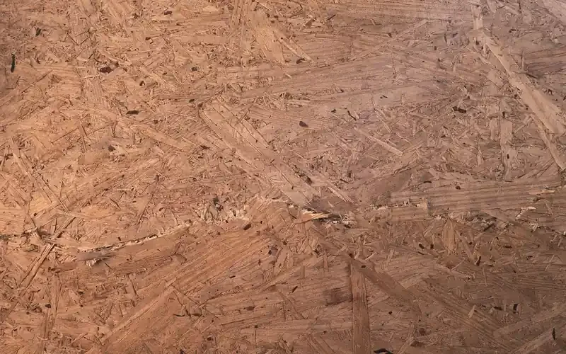 close-up detail of an OSB panel surface showing compressed wood strands and resin binder