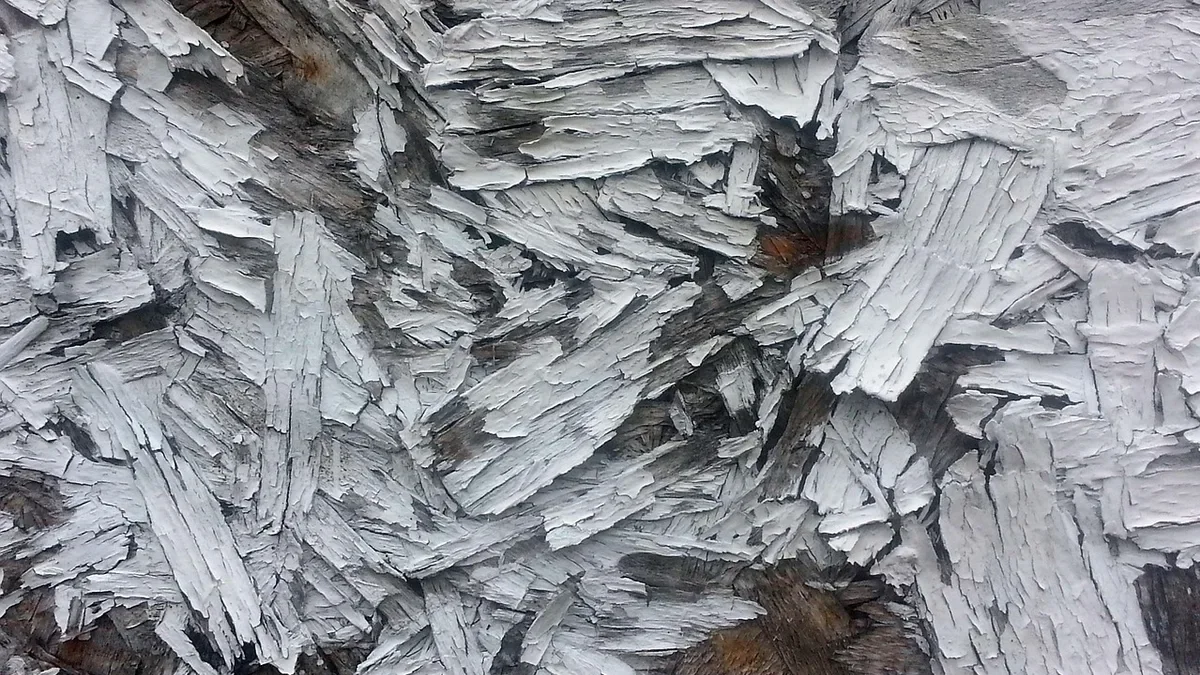 Old plywood panel with peeling white paint, a sign it needs separate disposal