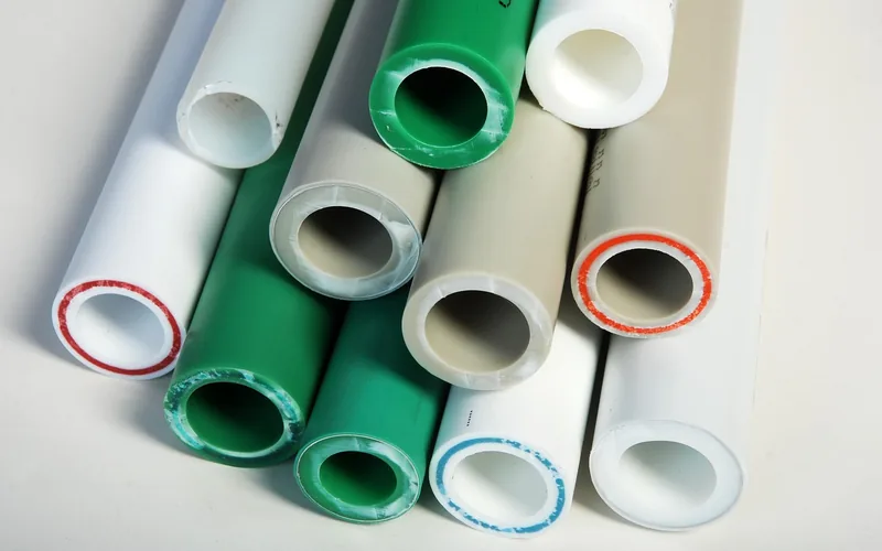 Stack of colored PVC and plastic pipes showing different plastic materials