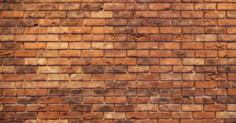 Weathered red brick wall showing the mortar joints plywood fasteners anchor into