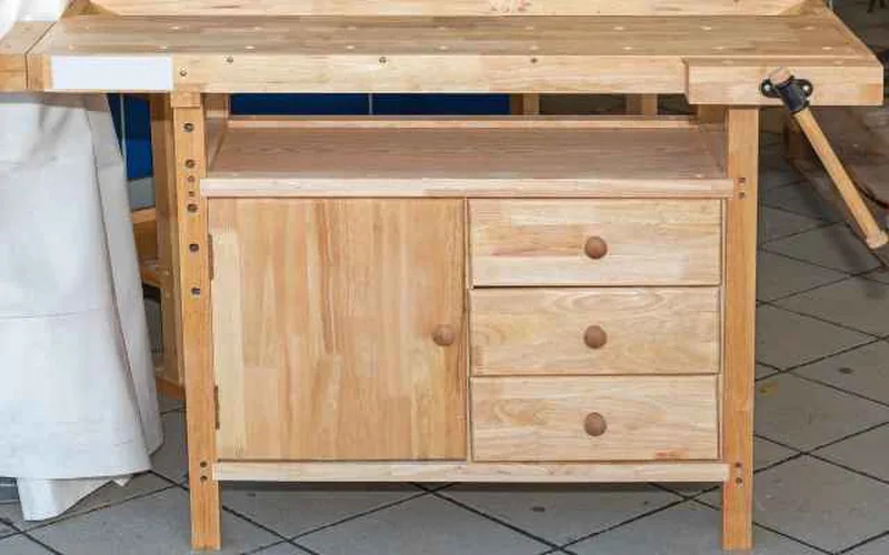 Light-wood plywood workbench with a lower storage cabinet and drawers