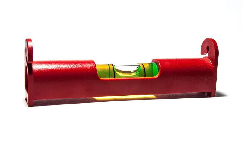 red spirit level tool used to check a shimmed connection for level