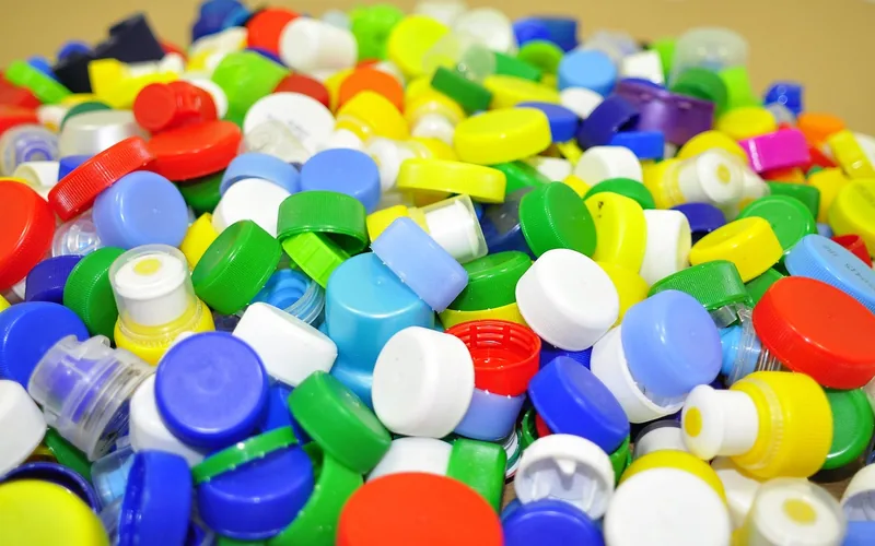 pile of colorful recycled plastic caps representing the plastic film blended into composite decking pile of colorful recycled plastic caps representing the plastic film blended into composite decking