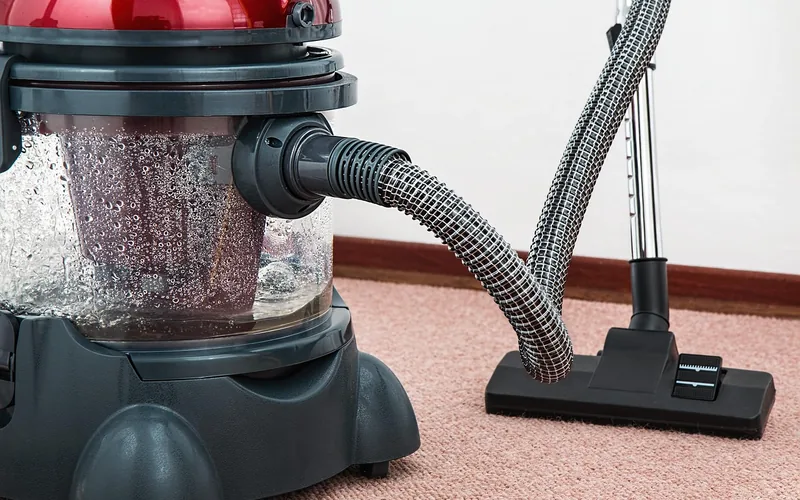 Vacuum cleaner being used on a carpeted living room floor