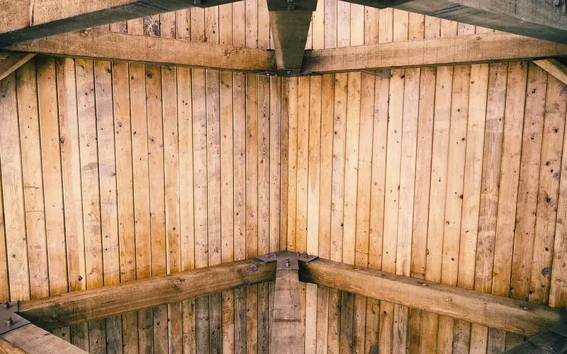 vaulted wood plank ceiling installed over exposed roof rafters