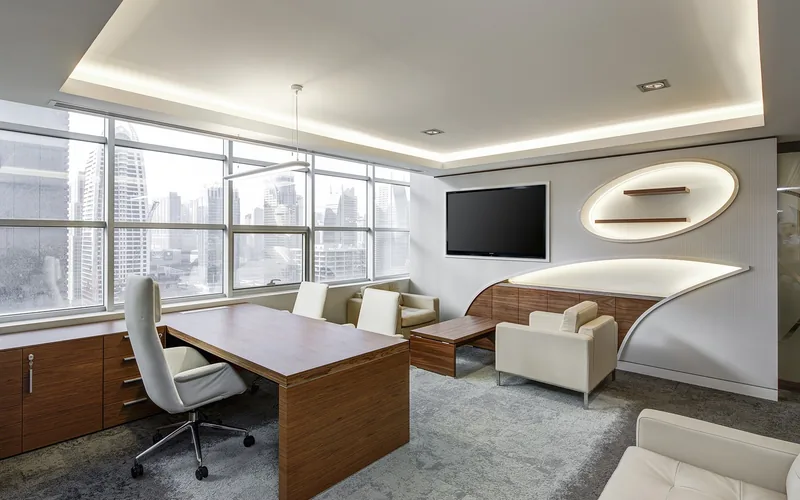 Warm brown wood desk and cabinetry in a neutral office with one dominant wood tone