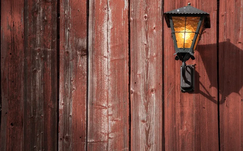 weathered red barn wood planks showing vertical grain and knots up close
