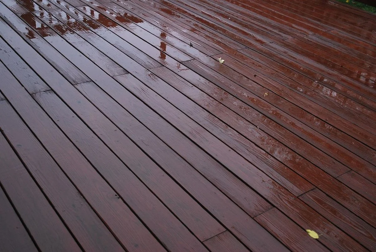 Rain water sitting on stained wood deck boards