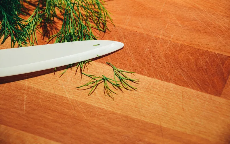 fresh herbs and a knife on a striped wood cutting board fresh herbs and a knife on a striped wood cutting board