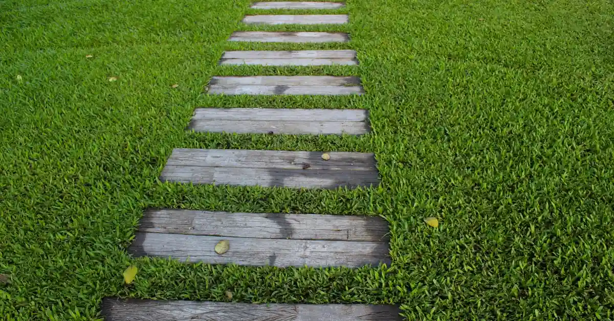 wood decking planks laid as a stepping path across a green lawn