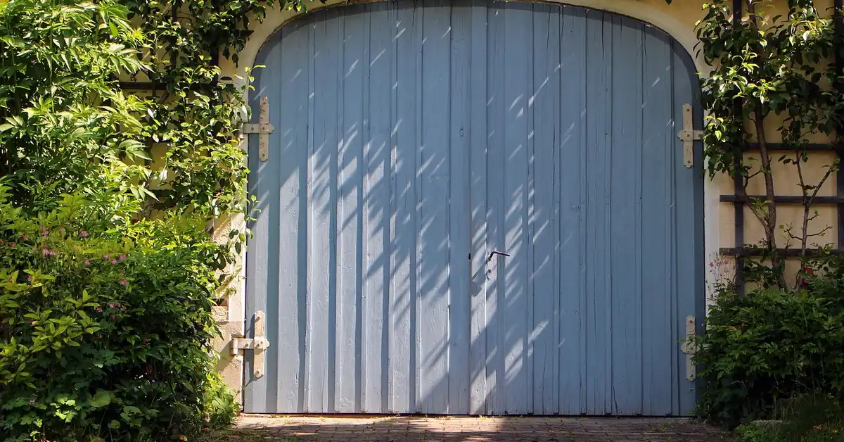 Wooden garage door with vertical plank construction before restaining