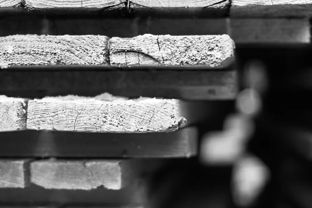 Stacked rough wood strips sticker-stacked for air drying at a lumber yard