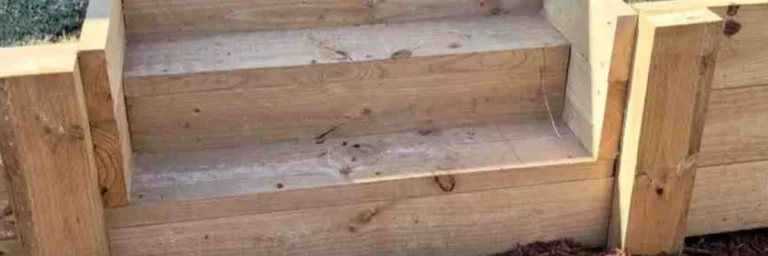 Wood retaining wall close-up showing built-in timber steps and horizontal plank construction