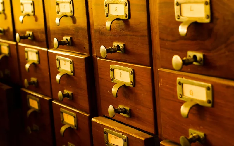 Rows of wooden drawers with brass pulls and label holders Rows of wooden drawers with brass pulls and label holders