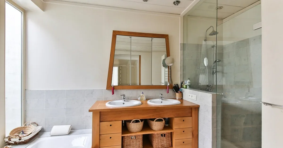 Solid wood bathroom vanity with two sinks under a wood-framed mirror
