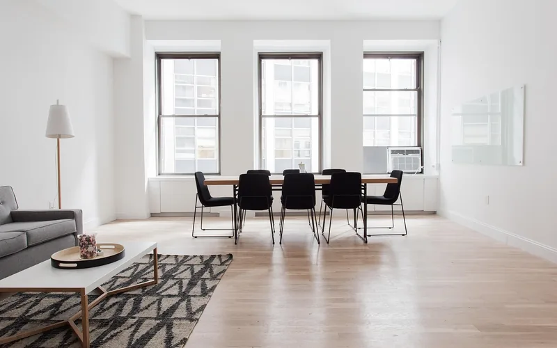 area rug laid over a hardwood floor in a furnished living room