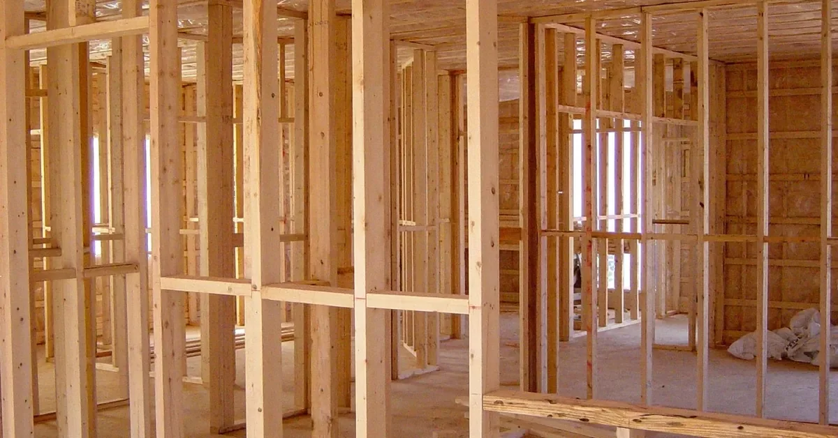 Open wood wall framing in a house under construction, ready for structural plywood sheathing
