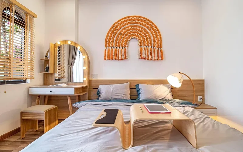 light-toned bent-ply wood furniture and headboard in a bedroom