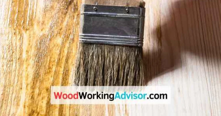Natural bristle brush applying oil-based wood stain to a pine board, showing even brush strokes along the grain