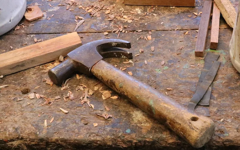 Woodworking hammer resting on a workbench covered in wood shavings