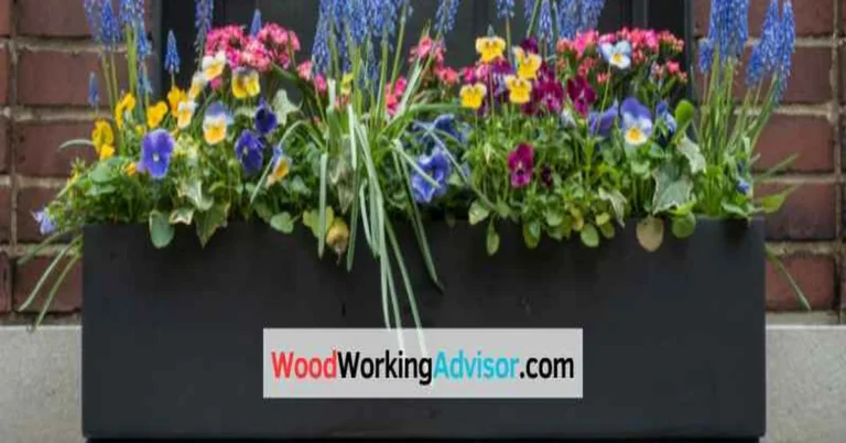 Cedar window box mounted under a window filled with pansies and grape hyacinth