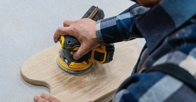 Random orbit sander smoothing the curved inside corner of a wood panel