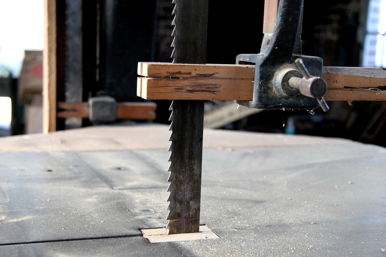 Band saw blade cutting through wood on the table
