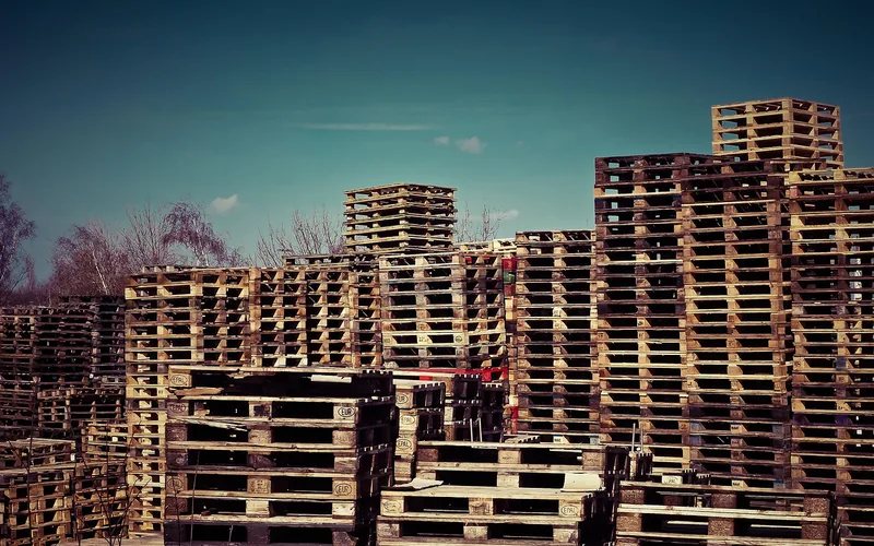 EPAL-stamped wood pallets stacked high at an outdoor recycling yard EPAL-stamped wood pallets stacked high at an outdoor recycling yard