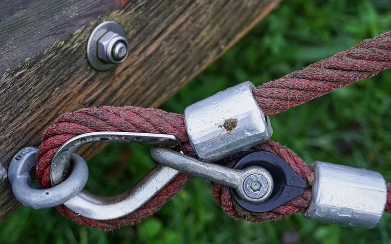 carabiner and eye-bolt hardware fastening a hammock rope to a wooden beam carabiner and eye-bolt hardware fastening a hammock rope to a wooden beam