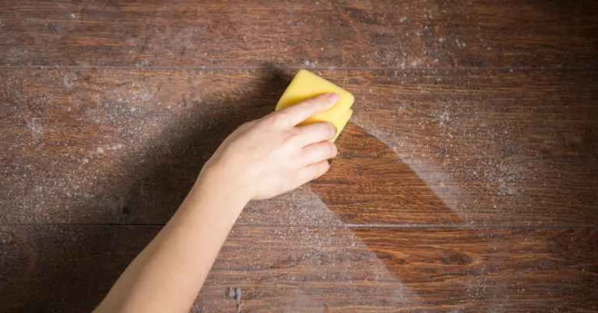 hand using yellow sponge to wipe a motor oil spill off a hardwood floor hand using yellow sponge to wipe a motor oil spill off a hardwood floor
