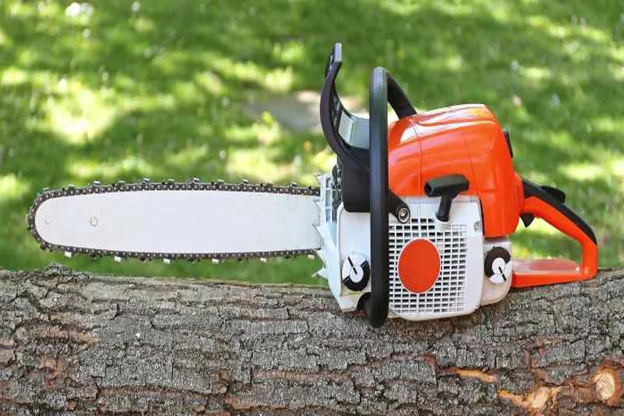 Homeowner-grade gas chainsaw with orange housing resting on a cut log