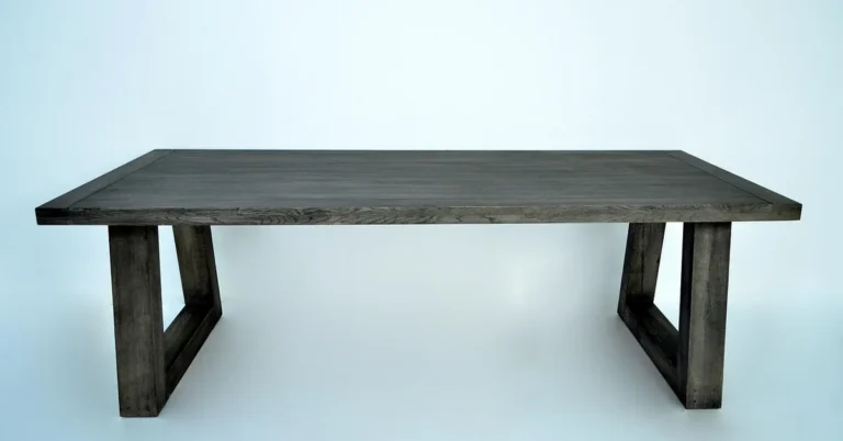 Solid oak dining table on two trestle legs inset from the tabletop ends